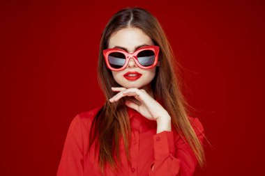 Kırmızı tişörtlü neşeli kadın. Güneş gözlüklü. Yakın plan.