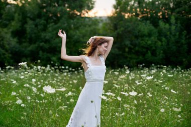 Beyaz elbiseli bir kadın doğada bir tarlada çiçek açıyor özgürlük yazı