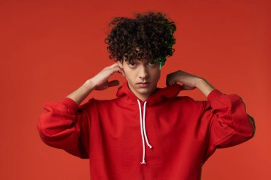 Kırmızı kazaklı bir adam kalp tatilinde poz veriyor.