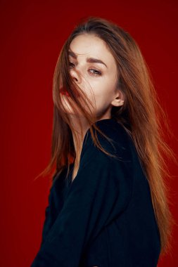 Kırmızı dudaklı güzel kadın kızıl saçlı Glamor kırmızı arka planda poz veriyor