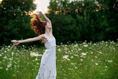 Beyaz elbiseli kadın dans doğası yaz pozu veriyor.