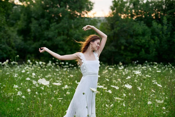 Donna in un abito bianco in un campo sulla natura fiori libertà estate — Foto Stock