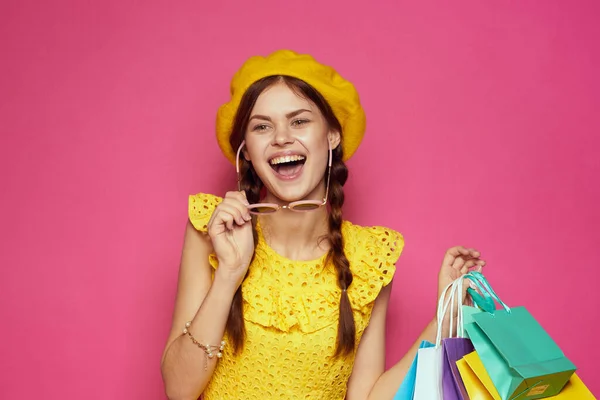 Vacker kvinna bär solglasögon poserar shopping mode rosa bakgrund — Stockfoto