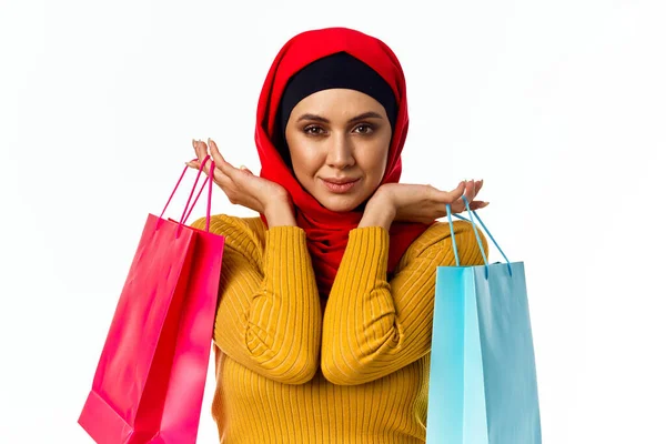 Veselý muslim žena nakupování dárky světlo pozadí — Stock fotografie