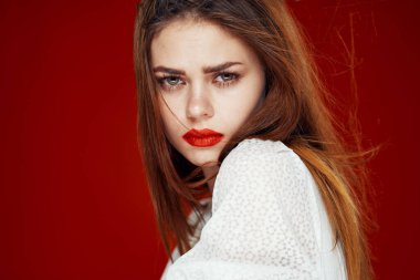 Kırmızı dudaklı, kırmızı dudaklı, beyaz elbiseli, modaya uygun bir kadın.