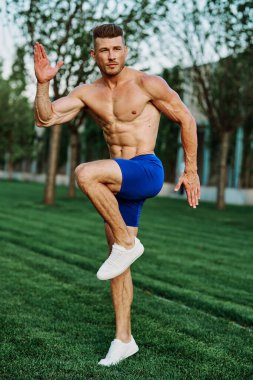 Adam parkta spor yapıyor. Açık havada kardiyo antrenmanı yapıyor.