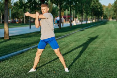Parktaki atletik adam yaz koşusu egzersizi yapıyor.