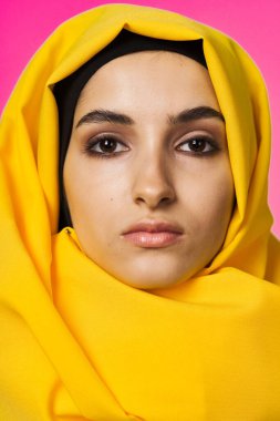 Müslüman kadın tesettürde moda kökenli pembe arka planda
