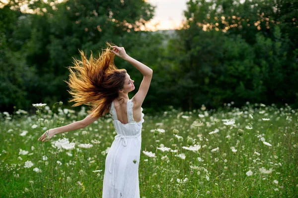 Mulher em um vestido branco em um campo na natureza flores liberdade verão — Fotografia de Stock