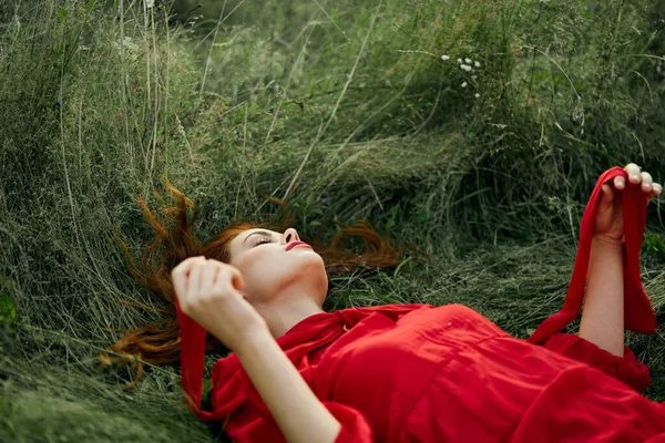 Nő piros ruhában feküdt a füvön friss levegő természet romantika — Stock Fotó