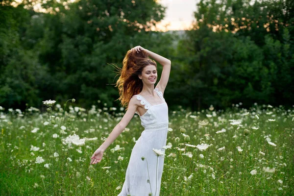 Donna in un abito bianco in un campo sulla natura fiori libertà estate — Foto Stock