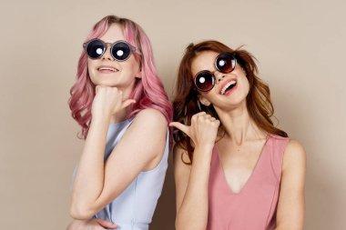 İki kız arkadaş yan yana durur. Lüks bir yaz pozu verir.