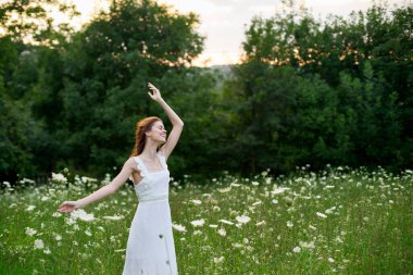 Beyaz elbiseli bir kadın doğada bir tarlada çiçek açıyor özgürlük yazı