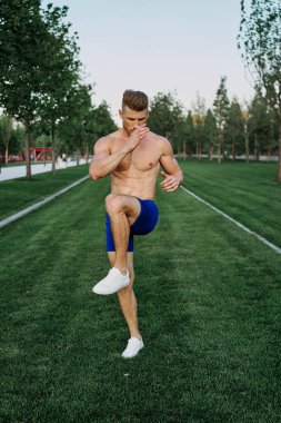 Parkta vücut egzersizi yapan atletik bir adam.