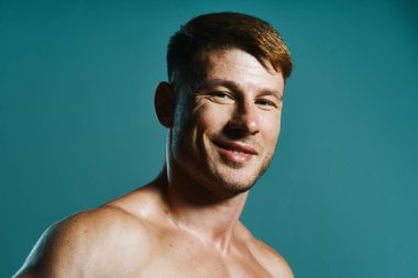 Vücudu kaslı, yeşil arka planı olan atletik bir adam.