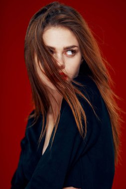 Kırmızı dudaklı güzel kadın kızıl saçlı Glamor kırmızı arka planda poz veriyor