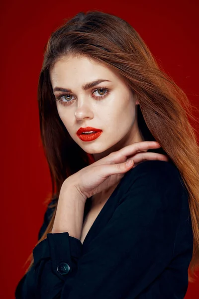 Kaunis nainen punaiset huulet punaiset hiukset Glamour poseeraa punainen tausta — kuvapankkivalokuva