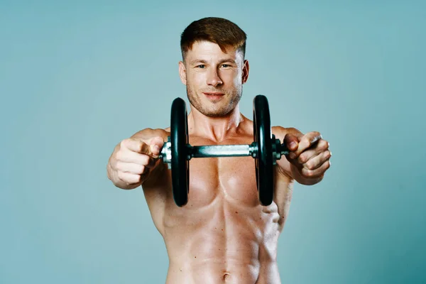 Fisiculturista com um corpo muscular com halteres em suas mãos fitness — Fotografia de Stock