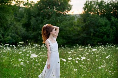 Beyaz elbiseli bir kadın doğada bir tarlada çiçek açıyor özgürlük yazı