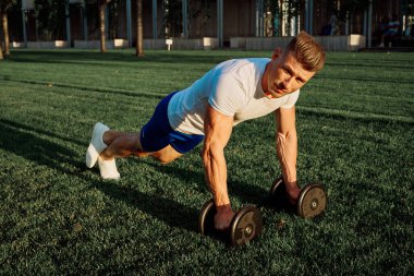 Parktaki adam yeşil çimen egzersiz egzersizi yapıyor.