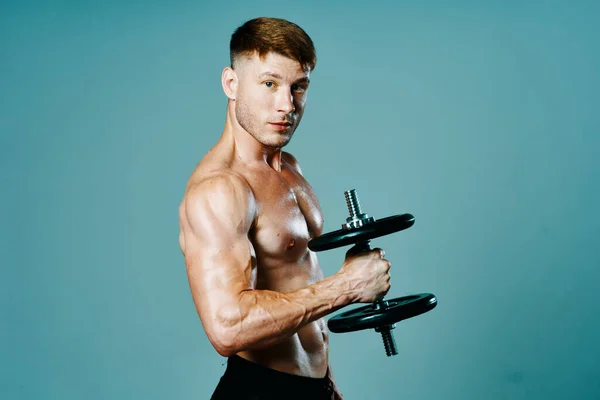 Bodybuilder met een gespierd lichaam met halters in zijn handen fitness — Stockfoto