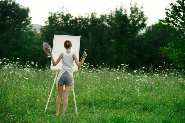 Artista na natureza pintando um quadro paisagem criativa vista para trás — Fotografia de Stock