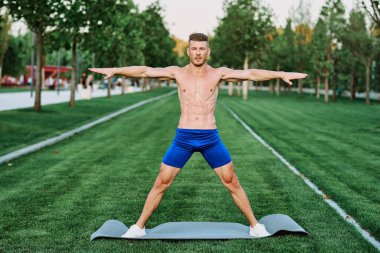 Sportif kaslı adam spor için parktaki spor motivasyonuna gidiyor.