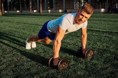 Parktaki adam yeşil çimen egzersiz egzersizi yapıyor.