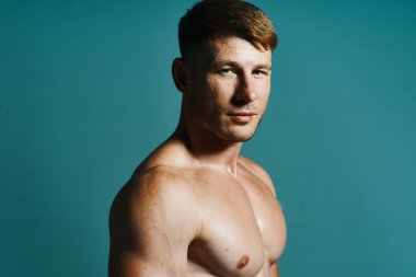 Vücudu kaslı, yeşil arka planı olan atletik bir adam.