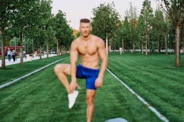 Adam parkta spor yapıyor. Açık havada kardiyo antrenmanı yapıyor.