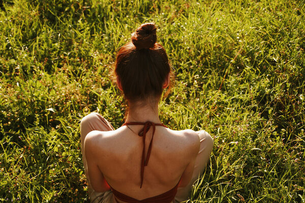 Woman in the field sitting on the grass meditation rest. High quality photo