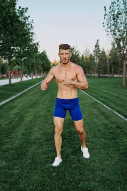 Parkta vücut egzersizi yapan atletik bir adam.