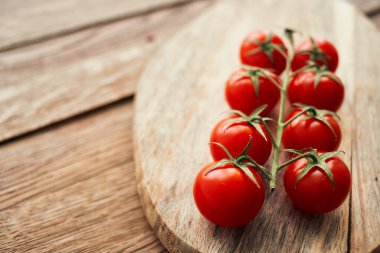 Tahta bir mutfak malzemesinin dalındaki kiraz domatesleri taze gıdalar.