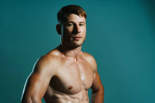 Atletische man met opgepompt gespierd lichaam workout groene achtergrond — Stockfoto