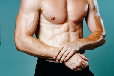 Kasları şişmiş atletik bir adam kas çalıştırıyor vücut geliştiriyor.