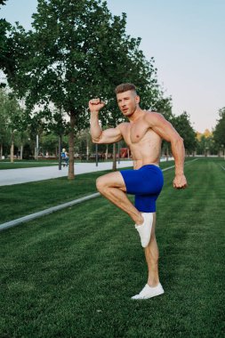 Parkta vücut egzersizi yapan atletik bir adam.