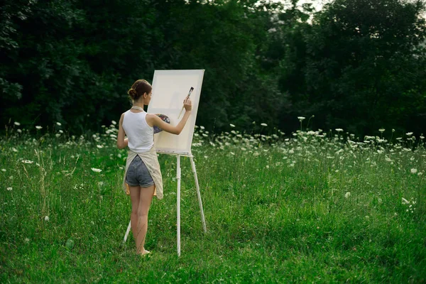 Vrouw kunstenaar in schorten verf palet ezel natuur — Stockfoto