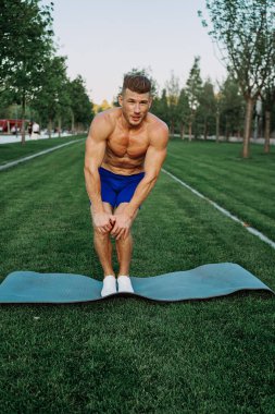 Parktaki şortlu sporcu dışarıda çalışıyor.