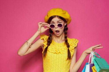 Güneş gözlüğü takan neşeli bir kadın alışveriş modasına giriyor.