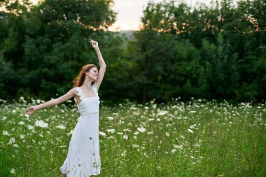 Beyaz elbiseli kadın dans doğası yaz pozu veriyor.