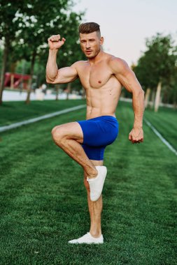 Adam parkta spor yapıyor. Açık havada kardiyo antrenmanı yapıyor.