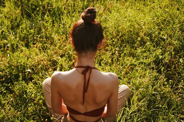 Kvinna på fältet sitter på gräset meditation vila — Stockfoto