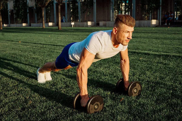 Parktaki adam yeşil çimen egzersiz egzersizi yapıyor.