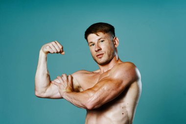 Kasları şişmiş atletik bir adam kas çalıştırıyor vücut geliştiriyor.