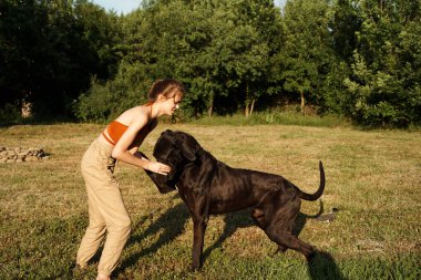Arkadaşlık sahasında dışarıda köpekçilik oynayan neşeli kadın.
