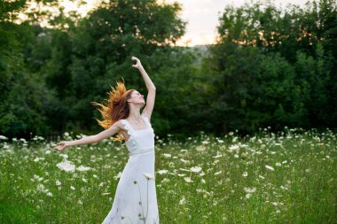 Beyaz elbiseli kadın dans doğası yaz pozu veriyor.