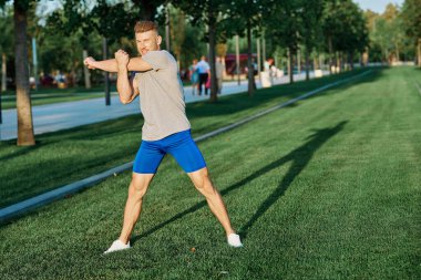 Parktaki atletik adam yaz koşusu egzersizi yapıyor.