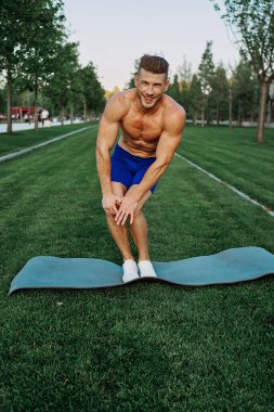 Parktaki şortlu sporcu dışarıda çalışıyor.