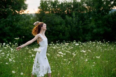 Beyaz elbiseli kadın dans doğası yaz pozu veriyor.