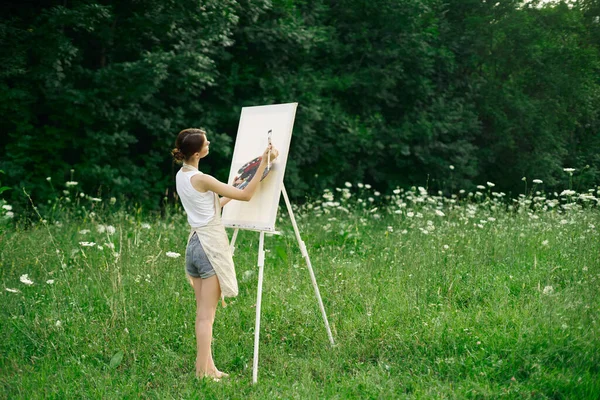 Vrouw kunstenaar in schorten verf palet ezel natuur — Stockfoto